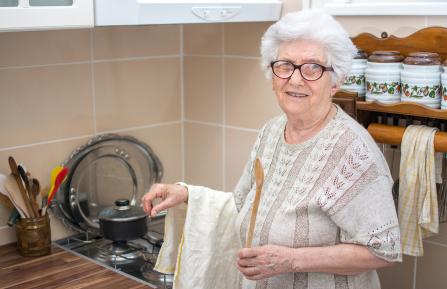 Senior citizen cooking at stove