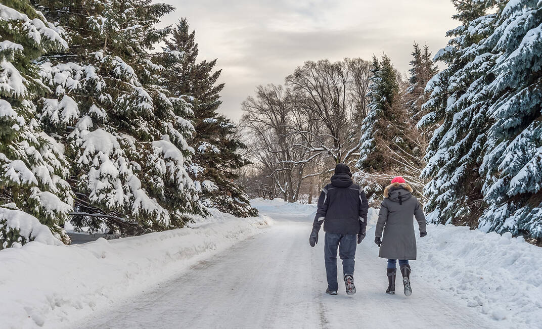 Two people go on a walk on an outdoor snowy trail