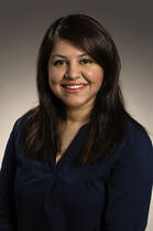 Fatima Shaukat, MD, a woman with mid-length dark hair, poses for a headshot wearing a dark long-sleeve shirt.