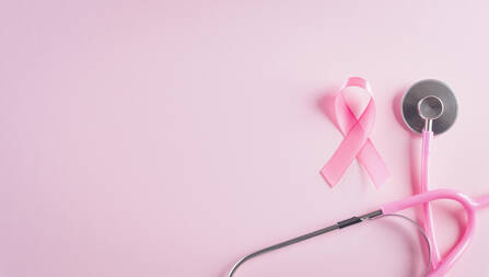 A pink stethoscope lays next to a pink ribbon on a pink background