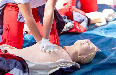 Person performing CPR on a dummy