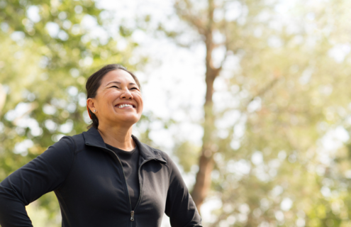 Woman looking happy while catching her breath in the woods