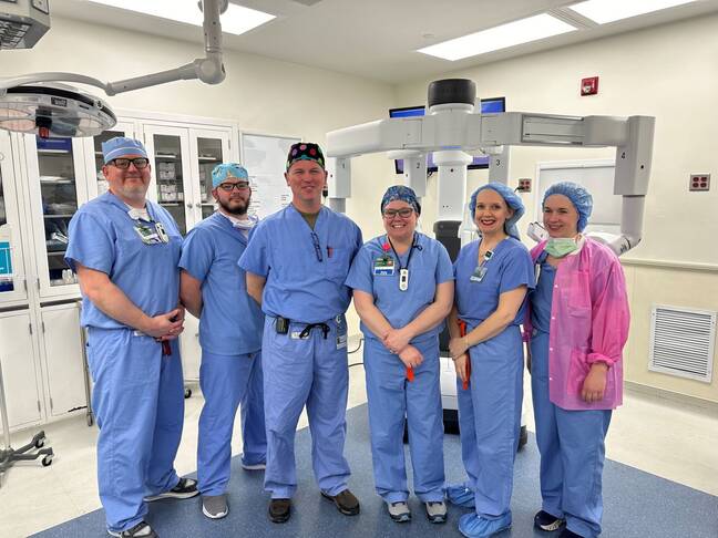 Photo of medical professionals with the robotic surgical platform